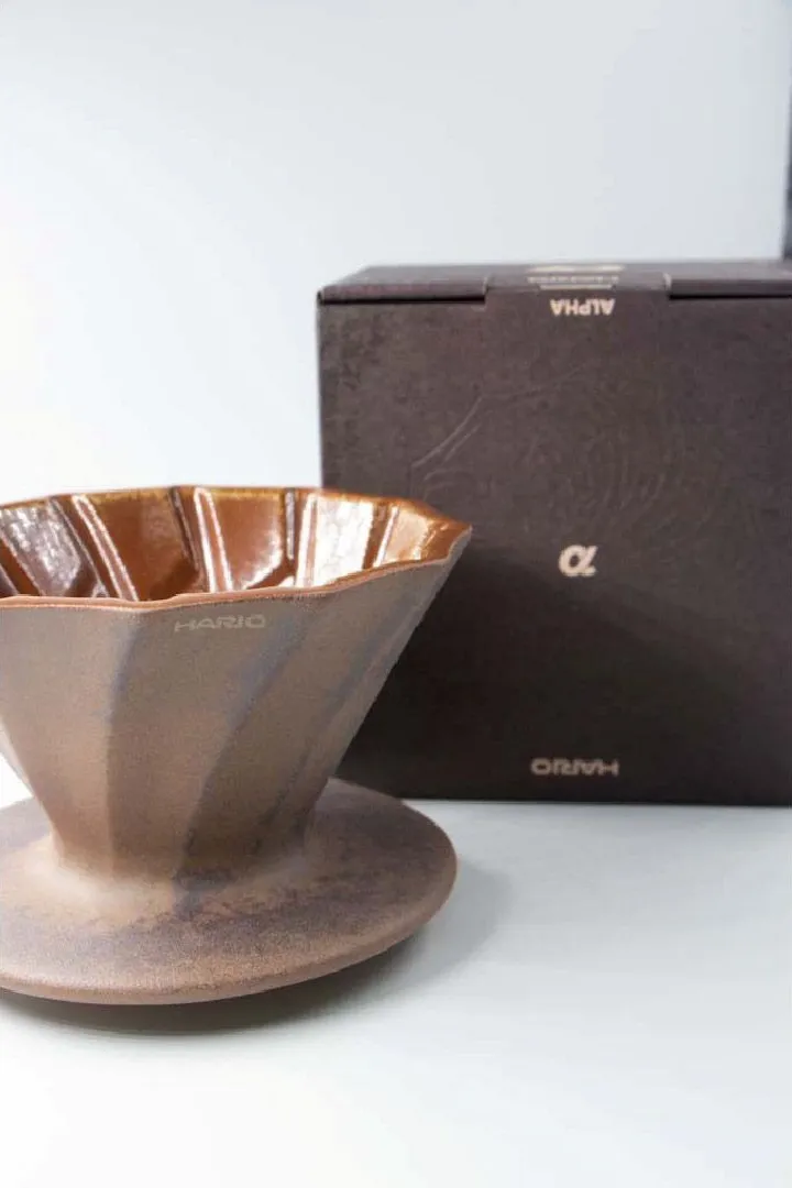 Alpha Lao Yan Ni dripper next to its dark brown box printed with an alpha symbol